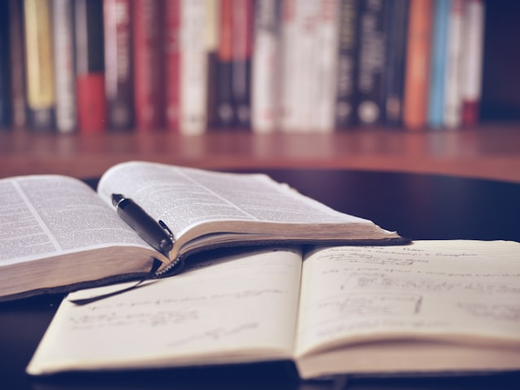 Open books and a notebook on a reading table